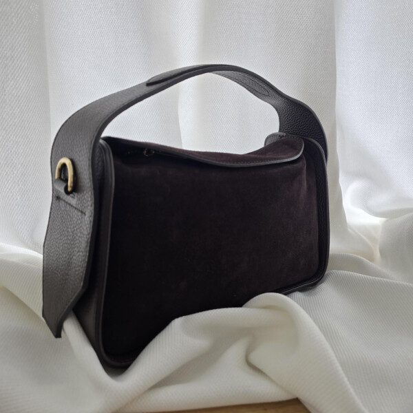 Elegantiška rankinė iš tamsiai rudos zomšos ir juodos natūralios odos. Minimalistinis dizainas, talpus vidus ir patogus platus dirželis – puikus pasirinkimas kasdienai ar išskirtinei progai.