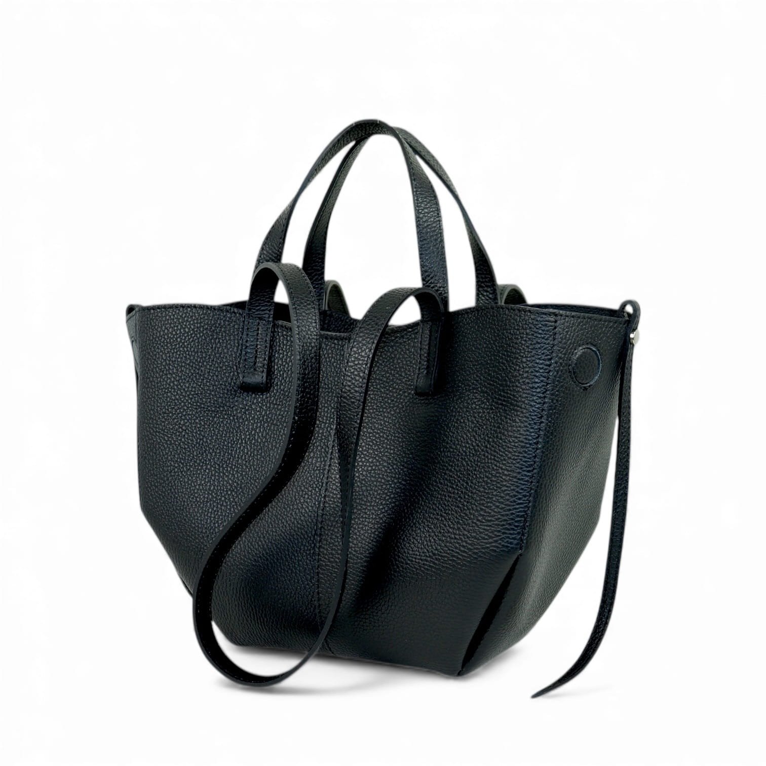 Juoda, grublėtos odos rankinė su minkšta, laisva forma. Turi dvi trumpas rankenas ir dvi ilgesnes peties rankenas. Minimalistinio dizaino, su subtiliomis siūlėmis ir mažu įspaustu apskritimu ties viršutiniu kraštu. Fotografuota švariame baltame fone.